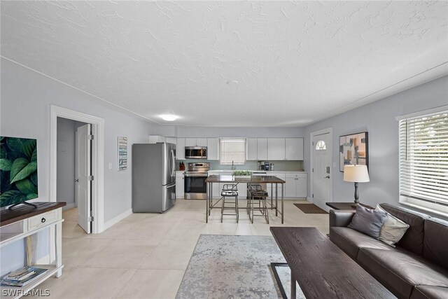 living room with a textured ceiling and light tile flooring