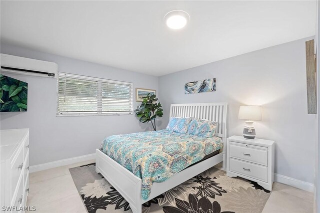 bedroom featuring light tile floors and a wall mounted air conditioner