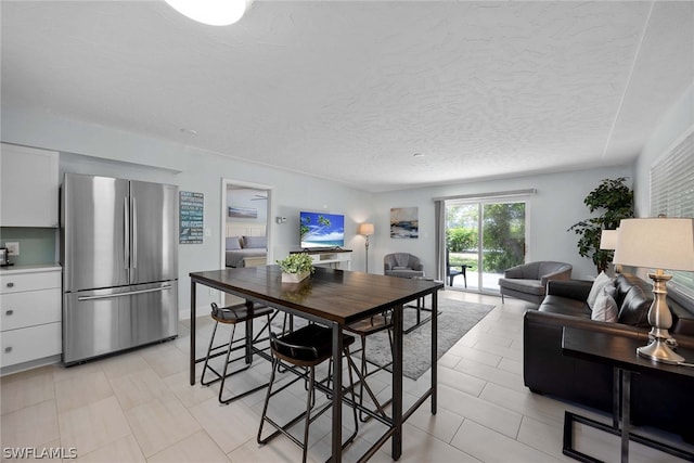 tiled dining area featuring a textured ceiling