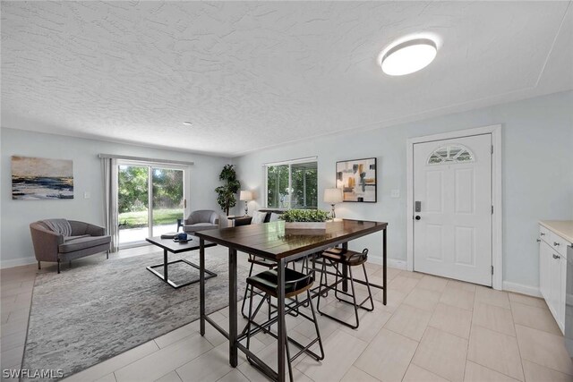 dining room with a textured ceiling and light tile floors