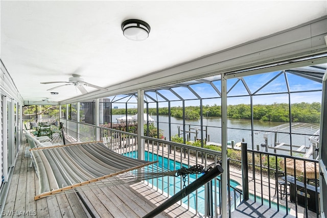 view of swimming pool featuring ceiling fan and a water view