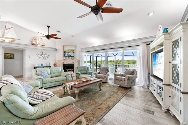 living room with lofted ceiling, light wood-type flooring, and ceiling fan