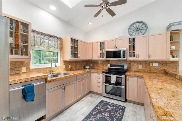 kitchen featuring appliances with stainless steel finishes, ceiling fan, light brown cabinetry, and tasteful backsplash