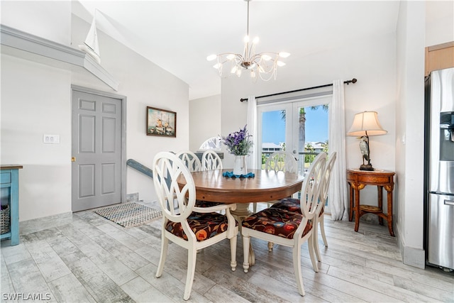 dining space with vaulted ceiling, an inviting chandelier, light hardwood / wood-style flooring, and french doors