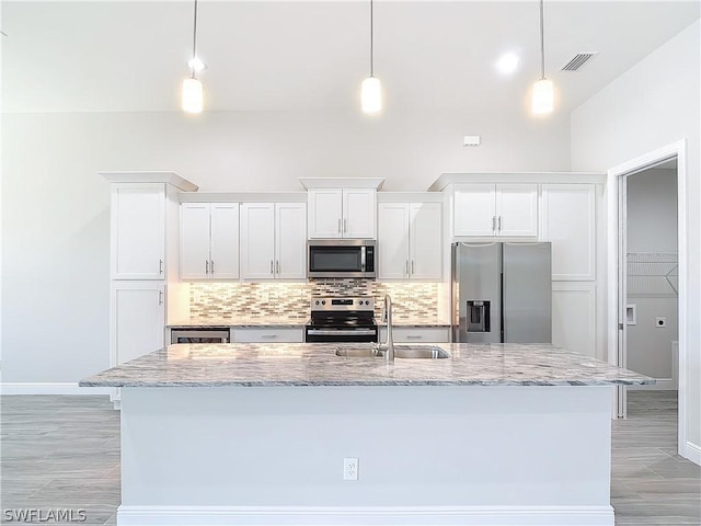 kitchen featuring pendant lighting, white cabinets, and appliances with stainless steel finishes