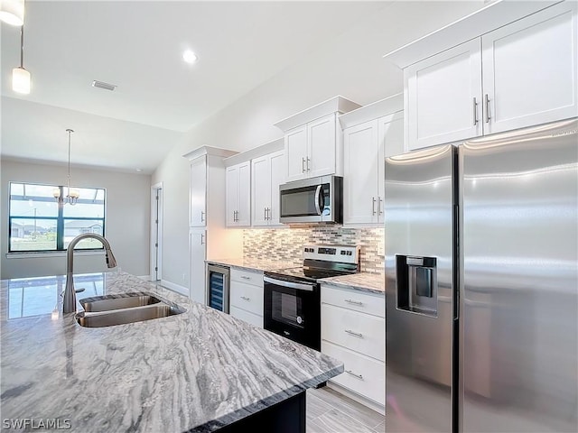 kitchen with wine cooler, sink, white cabinetry, hanging light fixtures, and stainless steel appliances