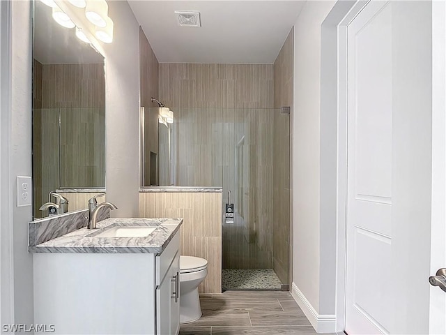 bathroom featuring walk in shower, vanity, and toilet