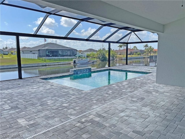 view of pool with pool water feature, a water view, glass enclosure, and a patio area