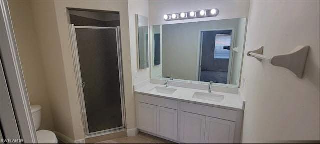 bathroom with vanity, tile patterned flooring, a shower with shower door, and toilet