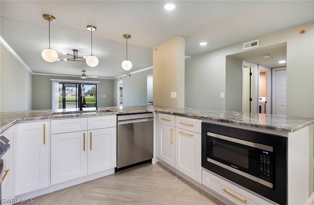 kitchen featuring appliances with stainless steel finishes, white cabinets, ornamental molding, kitchen peninsula, and pendant lighting