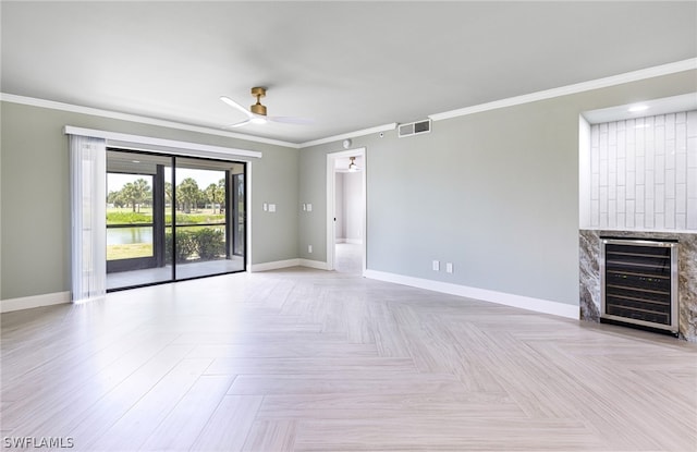 empty room featuring ceiling fan, light parquet floors, a fireplace, and crown molding