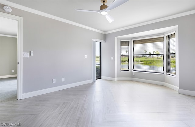 empty room with ornamental molding, ceiling fan, and light parquet floors