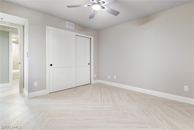 unfurnished bedroom with a closet, light parquet flooring, and ceiling fan