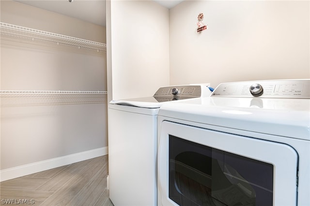 washroom featuring washer and clothes dryer and light hardwood / wood-style flooring