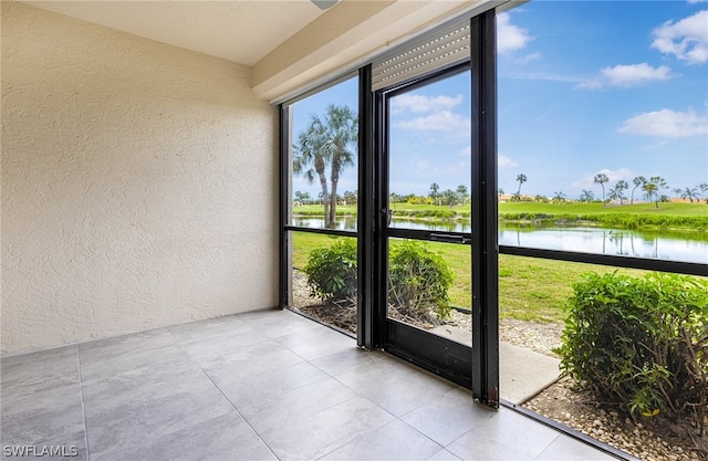 unfurnished sunroom featuring a water view