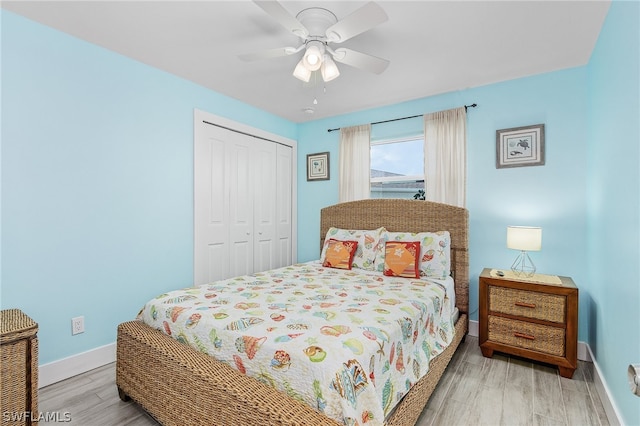 bedroom with ceiling fan, a closet, and light hardwood / wood-style floors