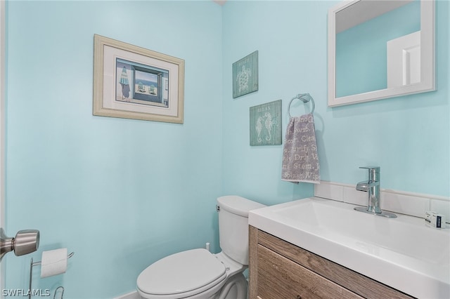 bathroom with vanity with extensive cabinet space and toilet