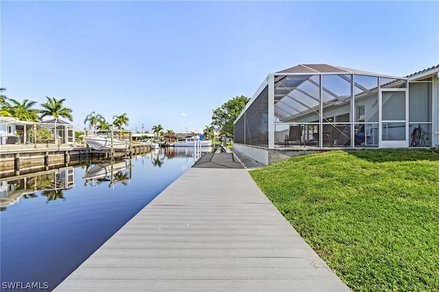 dock area with a lawn, a lanai, and a water view