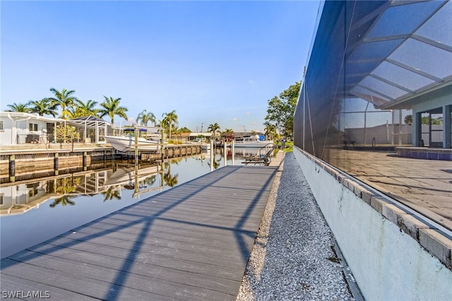 view of dock featuring a lanai and a water view