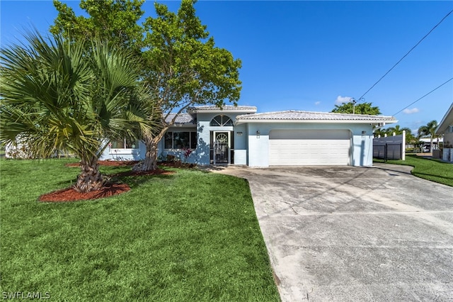 view of front of home with a garage and a front lawn