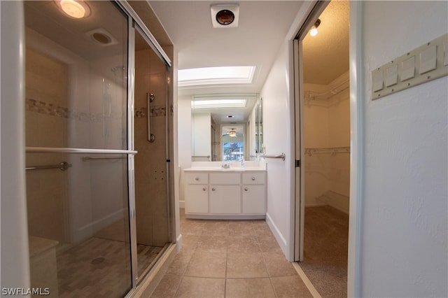 bathroom featuring an enclosed shower, vanity, and tile flooring