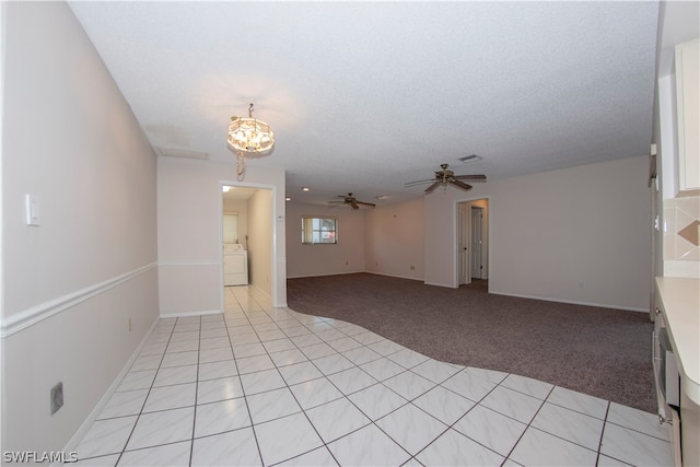 tiled spare room with a textured ceiling, ceiling fan, and washer / dryer