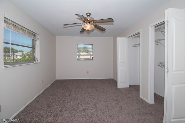 unfurnished bedroom with ceiling fan and dark carpet