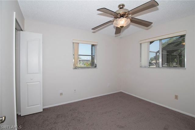 carpeted empty room featuring a textured ceiling and ceiling fan