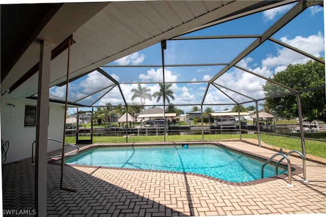 view of swimming pool featuring a patio, glass enclosure, and a lawn