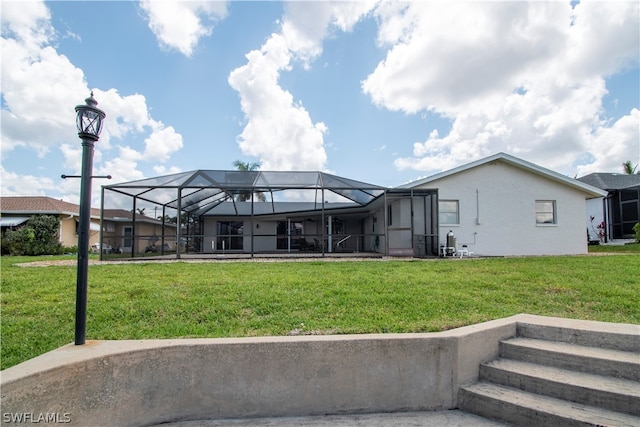 back of property featuring a yard and glass enclosure