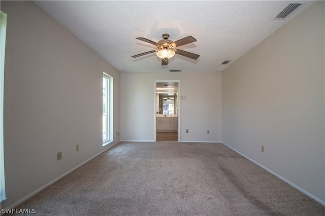 carpeted spare room with ceiling fan and a textured ceiling