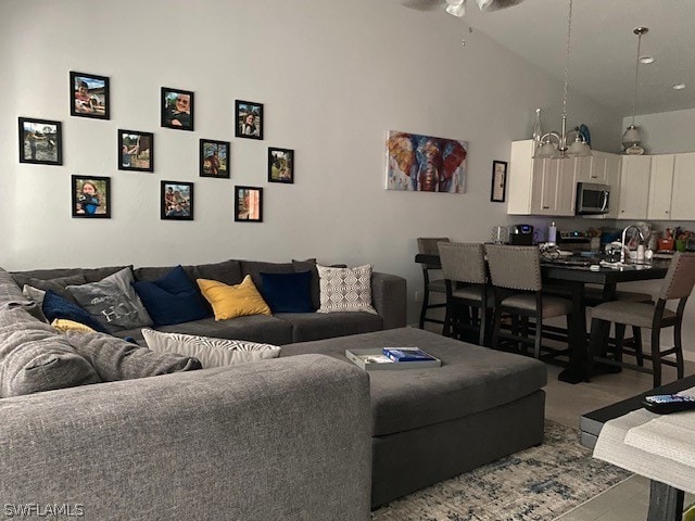 living room featuring tile floors, ceiling fan, high vaulted ceiling, and sink