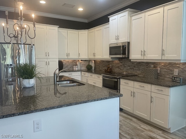 kitchen with white cabinets, appliances with stainless steel finishes, and ornamental molding