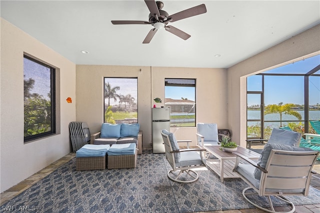 interior space with ceiling fan and a water view