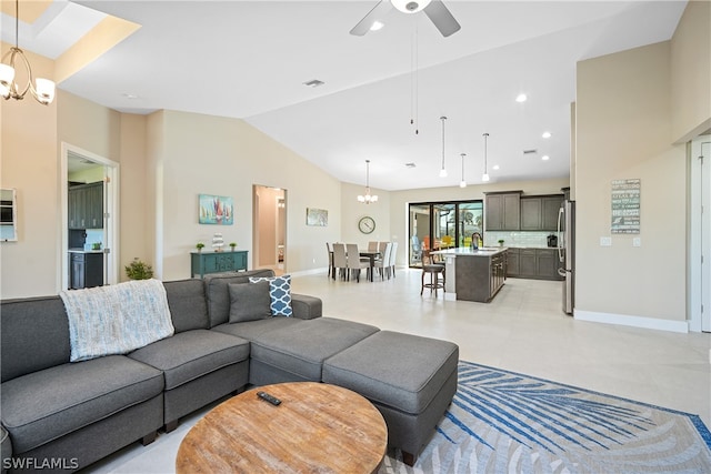 tiled living room with high vaulted ceiling, sink, and ceiling fan with notable chandelier