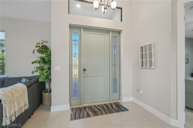 tiled entryway with plenty of natural light and an inviting chandelier