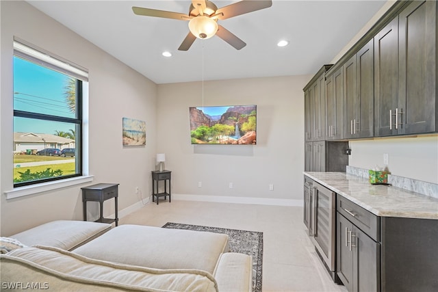 living room featuring ceiling fan, light tile floors, and beverage cooler