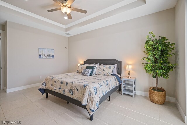 tiled bedroom featuring a raised ceiling and ceiling fan