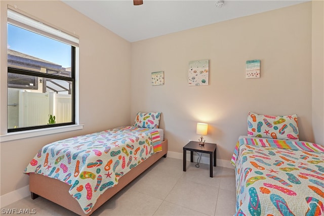 tiled bedroom featuring ceiling fan