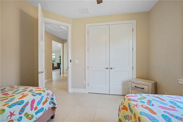 tiled bedroom featuring ceiling fan and a closet