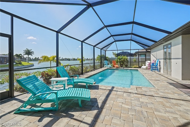 view of swimming pool with a patio area, a water view, pool water feature, and glass enclosure