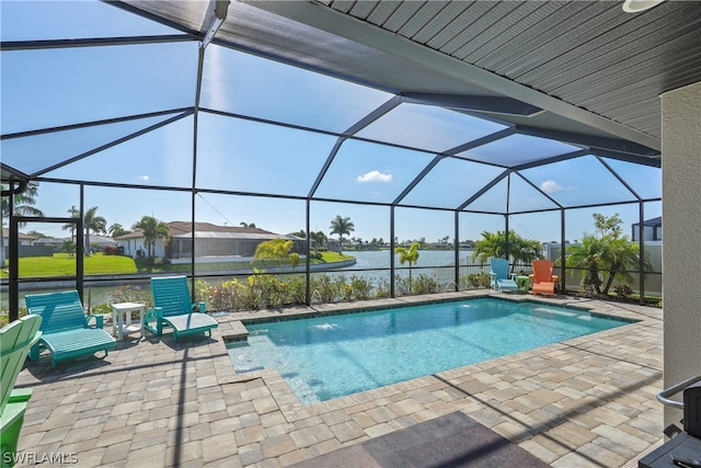 view of pool with a patio, pool water feature, and glass enclosure