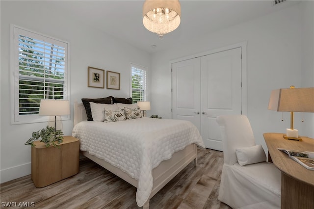 bedroom with a chandelier, hardwood / wood-style floors, and a closet