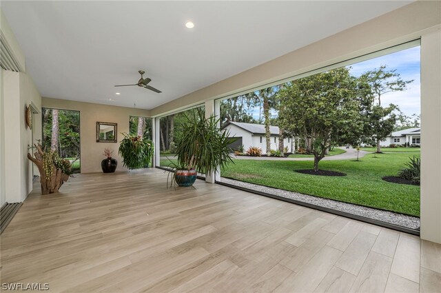 unfurnished sunroom with ceiling fan