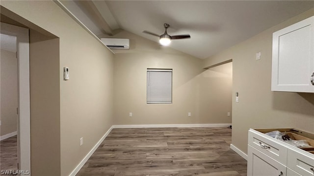 empty room with hardwood / wood-style flooring, ceiling fan, and lofted ceiling