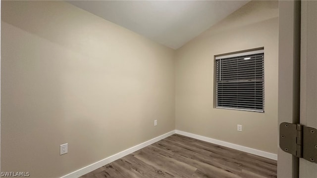 unfurnished room with vaulted ceiling and dark hardwood / wood-style floors