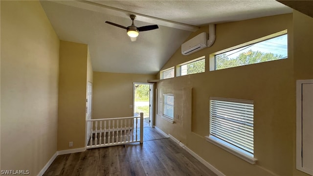 interior space featuring ceiling fan, a wall mounted air conditioner, a textured ceiling, lofted ceiling, and dark hardwood / wood-style flooring