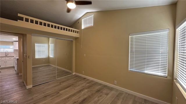 spare room with hardwood / wood-style floors, lofted ceiling, ceiling fan, and sink