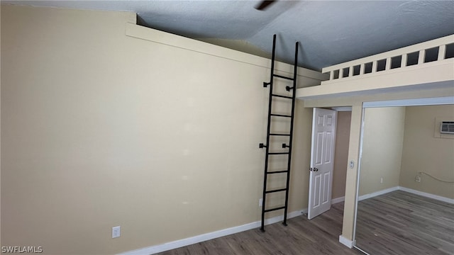 spare room with lofted ceiling, dark hardwood / wood-style floors, and a textured ceiling