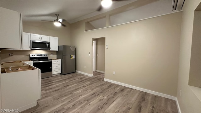 kitchen featuring appliances with stainless steel finishes, light hardwood / wood-style flooring, ceiling fan, and white cabinetry